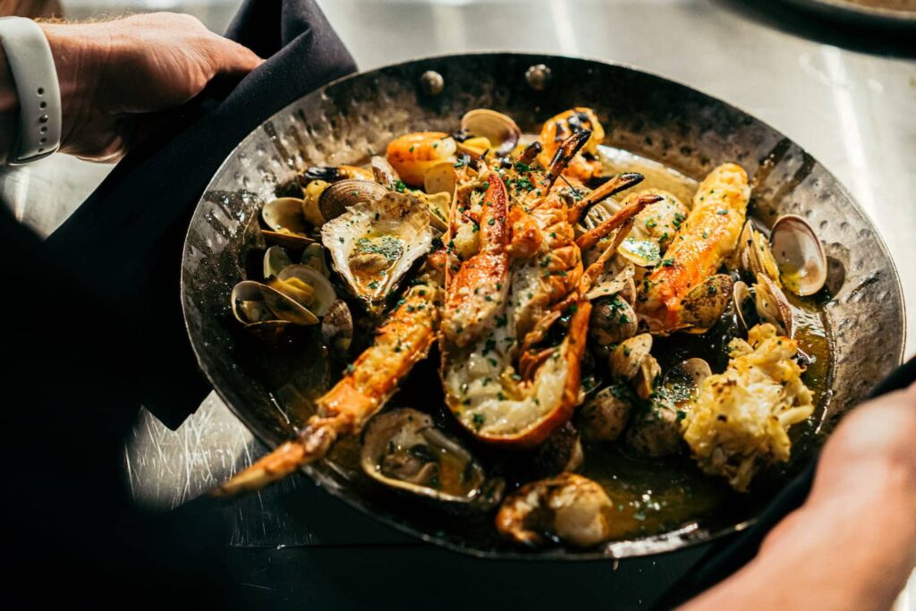 Fire roasted seafood in a roasting pan at Maple & Ash