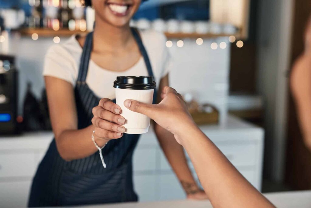 Closeup of a barista serving coffee to a customer